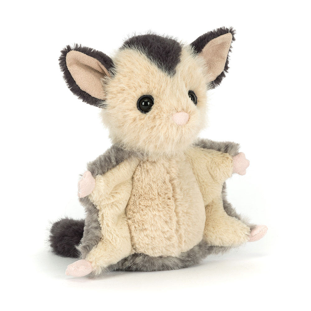 The Jellycat Lolly Sugar Glider is a plush toy with cream and gray fur, big ears, large black eyes, and outstretched limbs, sitting upright against a white background.